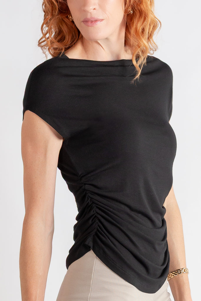 Woman wearing a black top with a draped design on a white background