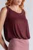 Woman wearing a maroon sleeveless top and skirt on a white background