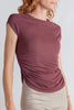 Woman wearing a mauve top with a plain background