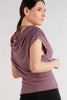 Woman wearing a mauve top and black skirt on a plain background