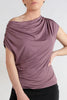 Woman wearing a mauve top and black pants on a white background