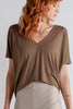 Woman wearing a brown V-neck top made of Tecel. 