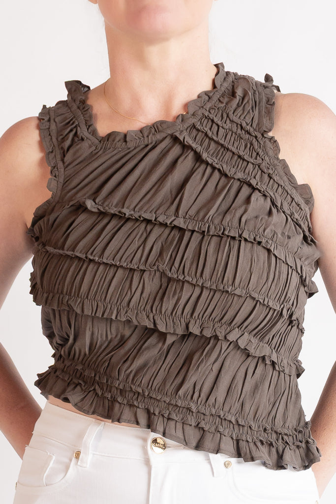 Brown ruffled top worn by a person on a plain background