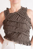 Brown ruffled top worn by a person on a plain background