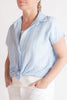 Woman wearing a light blue striped shirt with a white background