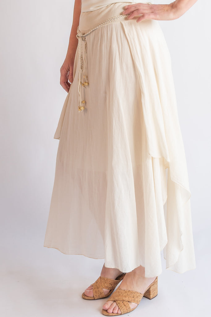 Beige skirt with drawstring waist and white top on a plain background