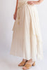 Beige skirt with drawstring waist and white top on a plain background