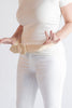 Person wearing a beige belt with a white background