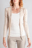 Woman wearing a beige cardigan, white top, and beige pants on a light gray background