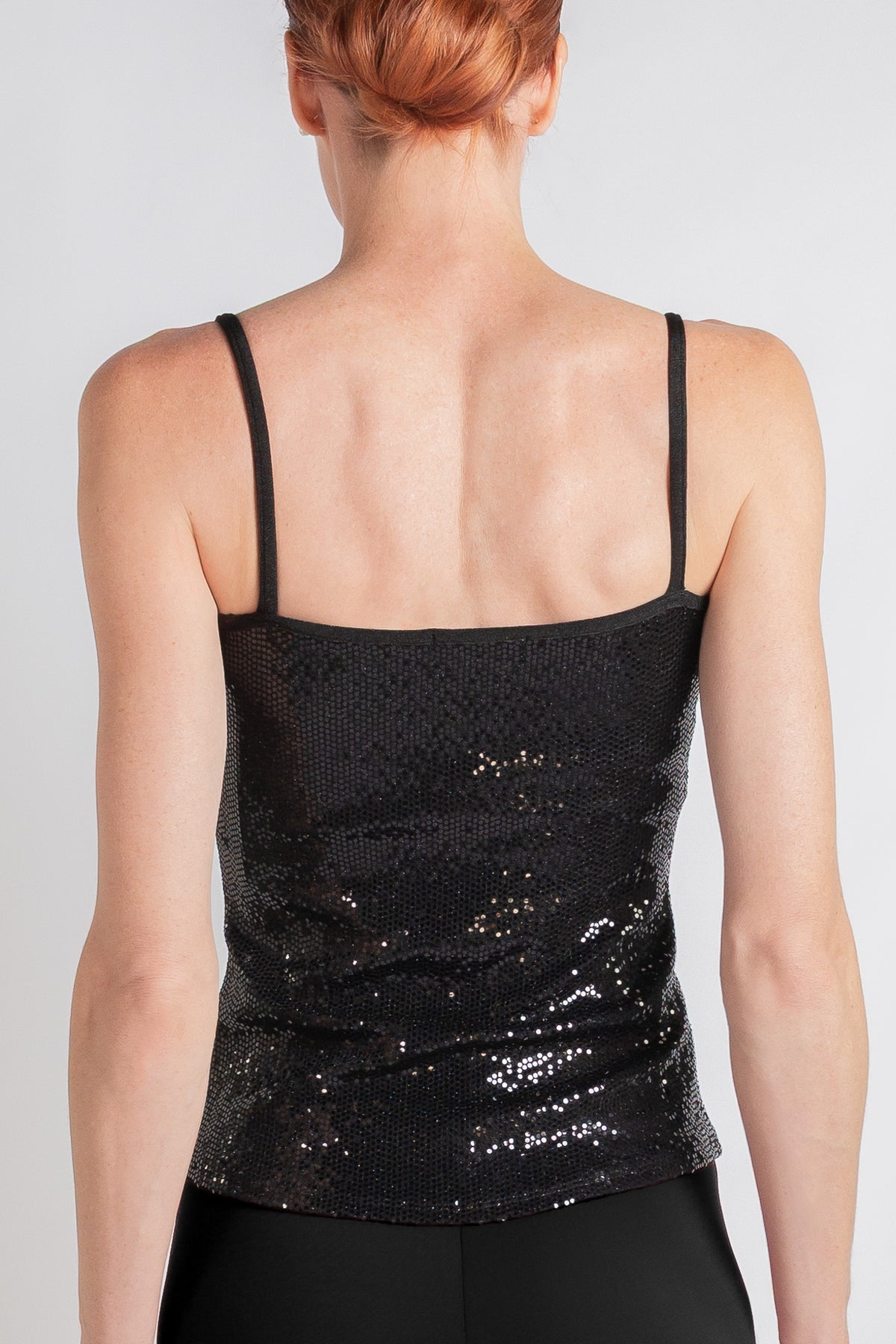 Woman wearing a black sequin cami, back view