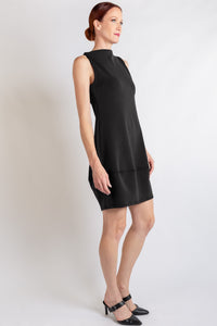 A sleeveless black mock-neck dress, shown in side view on a model against a plain white background.