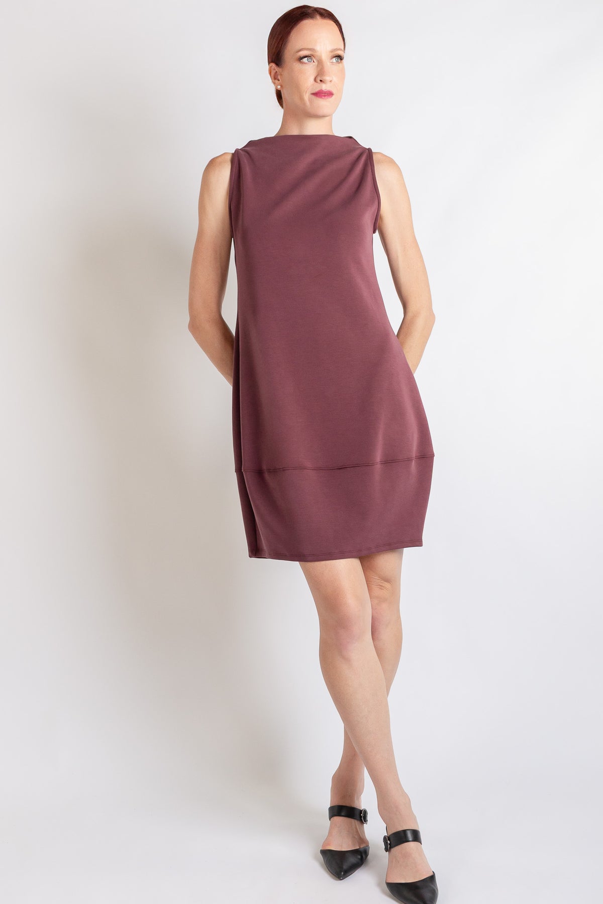A sleeveless merlot mock-neck dress, shown on a model against a plain white background.