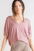 Woman wearing a pink top and beige wide-leg pants on a white background