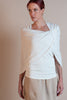 A woman wearing an ivory, double-layered mesh shrug with a twist design at the front, draped over the shoulders.