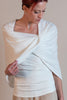A woman wearing an ivory, double-layered mesh shrug with a twist design at the front, draped over the shoulders.