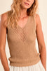 Woman wearing a beige knitted sleeveless top against a plain background