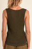 Woman wearing a ribbed knit tank top and brown pants on a beige background