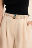 Woman wearing a black top and beige skirt on a beige background