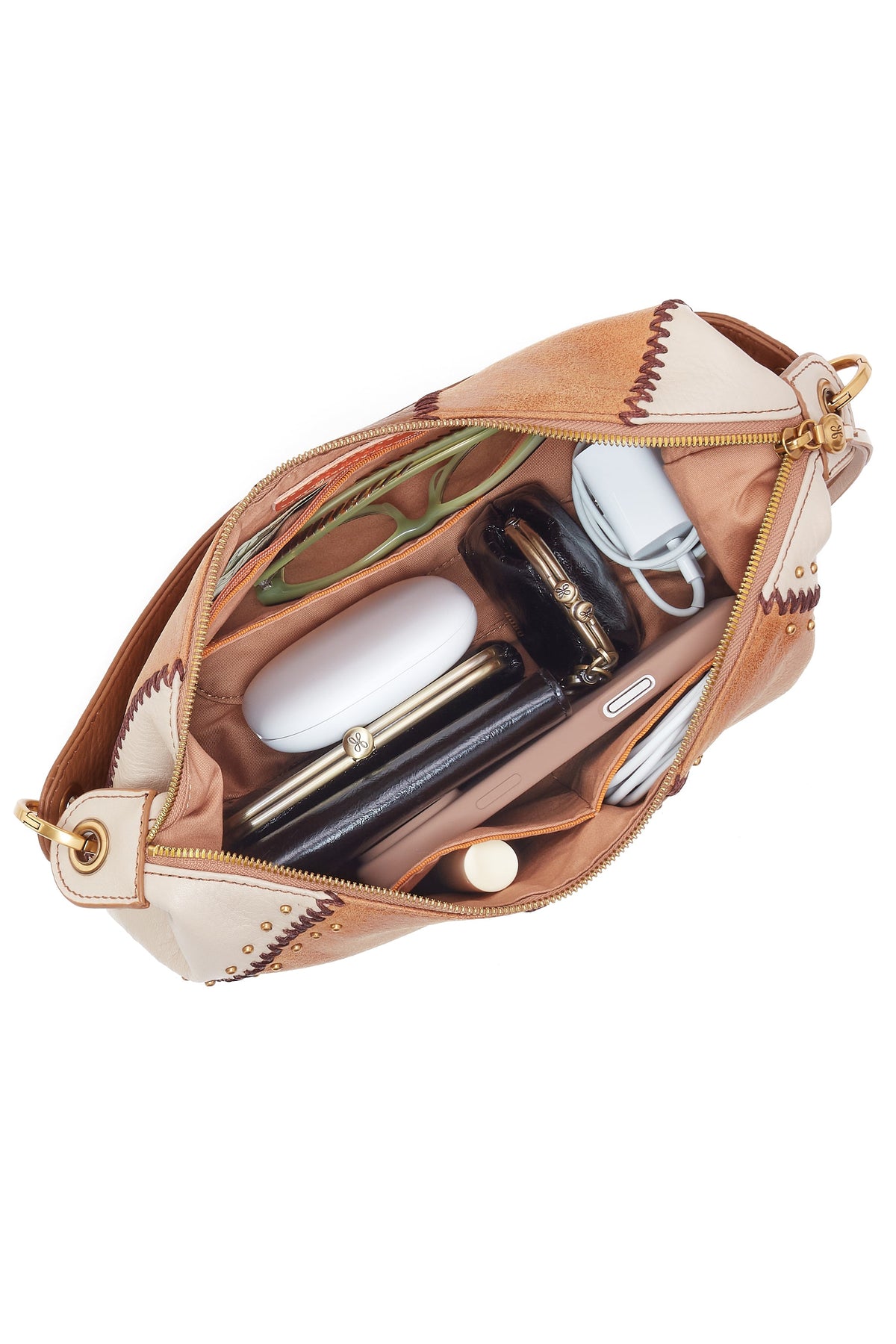Open beige cosmetic bag with various items on a white background