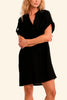 Woman wearing a black dress standing against a plain background