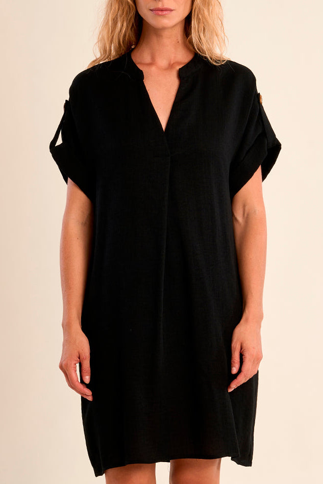 Woman wearing a black dress against a beige background