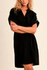 Woman wearing a black dress with crossed arms on a beige background
