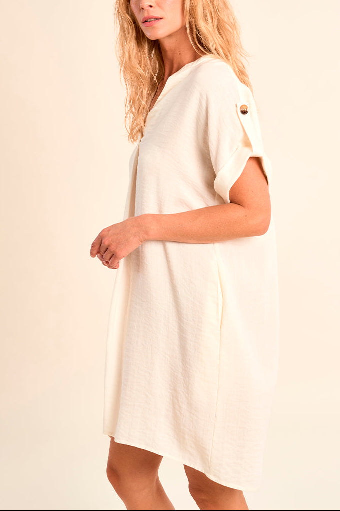 Woman wearing a white dress against a beige background