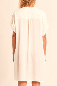 Woman wearing a white dress on a beige background