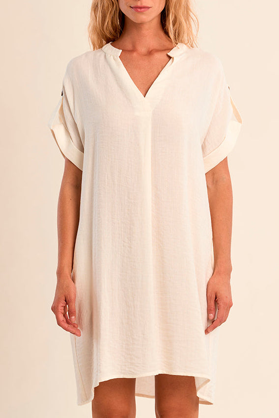 Woman wearing a white dress against a beige background