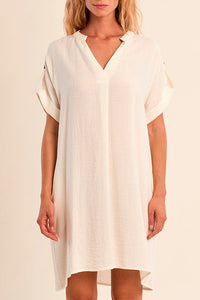 Woman wearing a white dress against a beige background