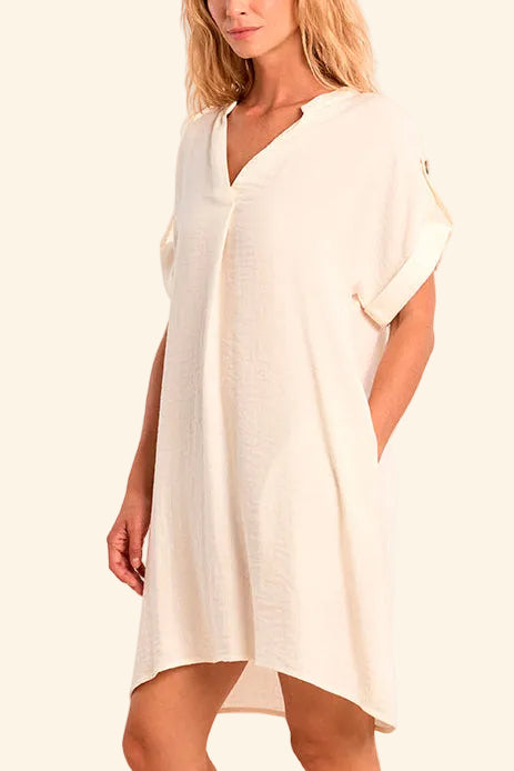 Woman wearing a white dress on a beige background