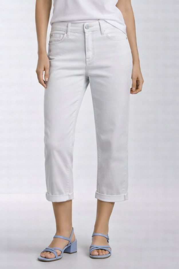 Woman wearing a white t-shirt and white pants on a light gray background