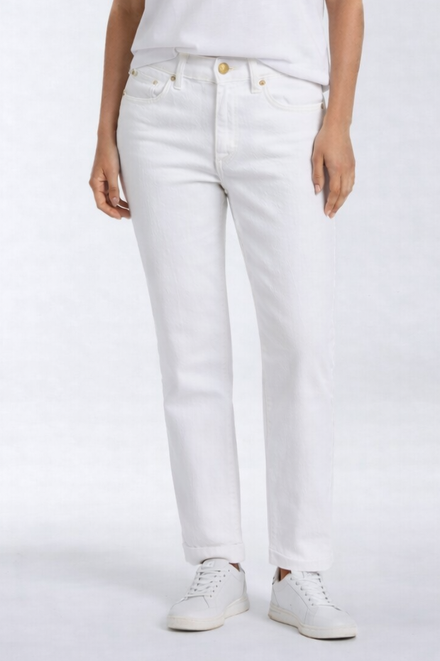 Woman wearing a white t-shirt and white pants on a light gray background