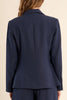 Person wearing a navy blue suit with shorts on a beige background