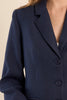 Navy blue blazer with a button on a neutral background
