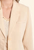 Close-up of a beige blazer with a button detail