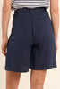 Person wearing navy shorts on a beige background