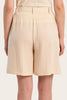Beige shorts worn by a person on a beige background