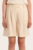 Person wearing a beige skirt on a plain background