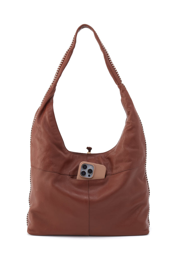 Brown leather handbag with a decorative button on a white background