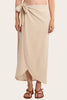 Woman wearing a beige wrap skirt on a plain background