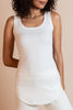 Model wearing the ivory Hedy Tunic Tank, a ribbed tunic-length tank with curved hem and round neckline, styled for everyday layering