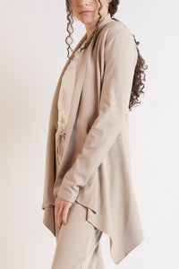 Woman wearing a long sleeve jacket in Dove. 